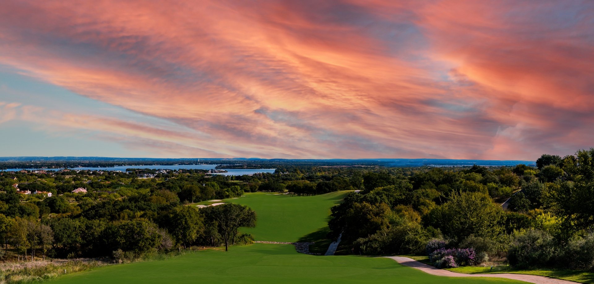 Red and orange sunset on a golf course overlooking the Texas Hill Country landscape.