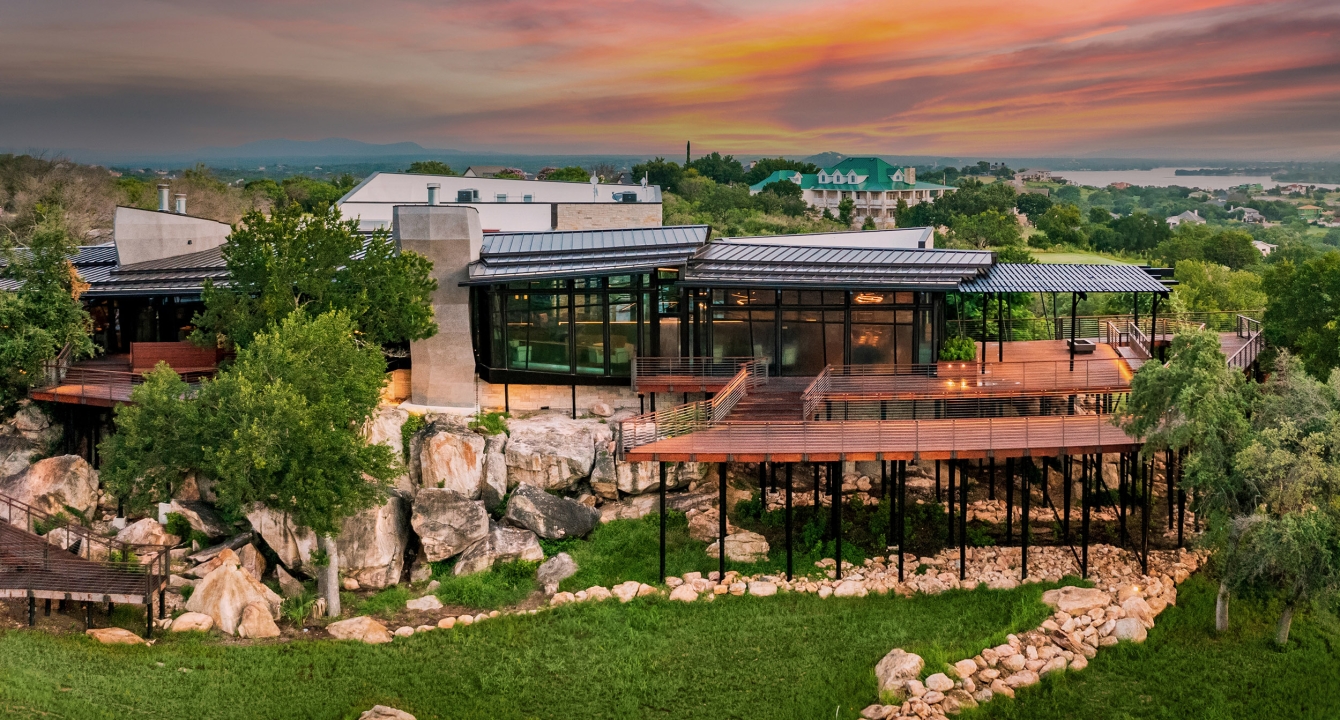 Cap Rock clubhouse with a beautiful orange and pink sunset in the distance.