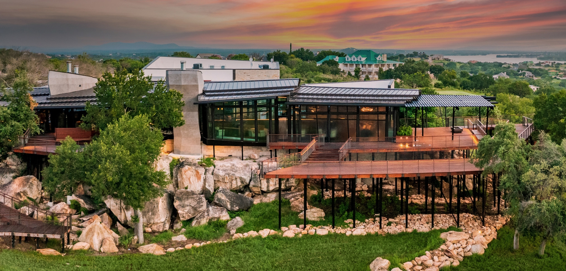 Cap Rock clubhouse with a beautiful orange and pink sunset in the distance.