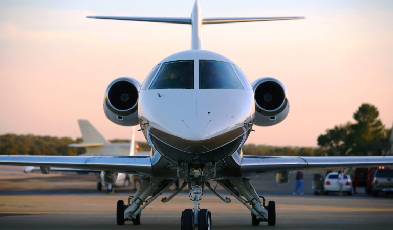 head on view of a jet about to take off with a sunset.