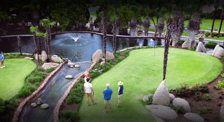 guests enjoying putting in front of fountain
