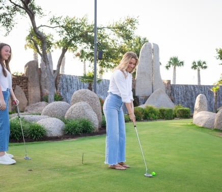 2 women playing mini golf at the whitewater putting course at horseshoe bay resort