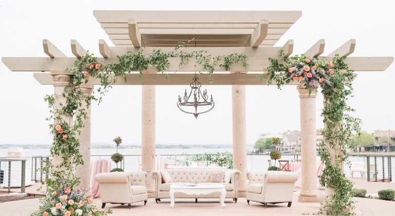 venue space in the Texas Hill Country. Large Arch with flowers overlooking the water.