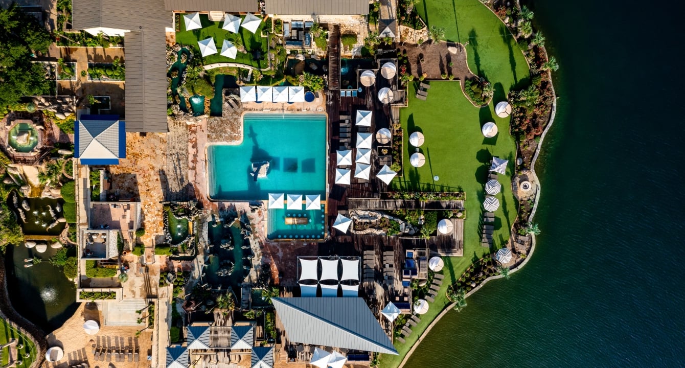 birds eye view of the lake and our yacht club that contains a pool, bar and umbrellas.