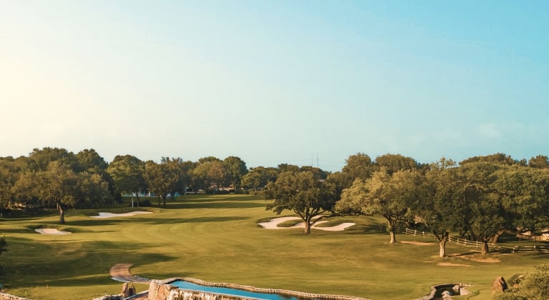 a golf course at horseshoe bay resort on a sunny day with trees and water