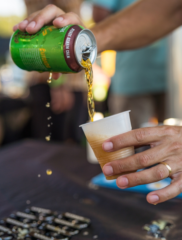 someone pouring beer into a cup