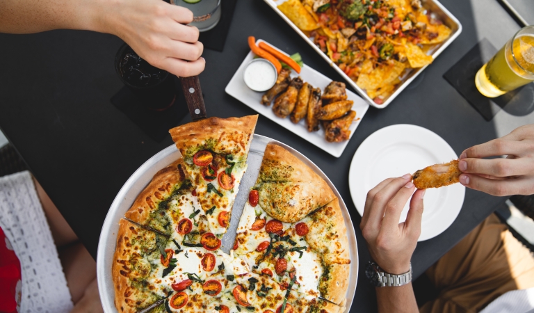 people enjoying pizza, wing and nachos at horseshoe bay resort
