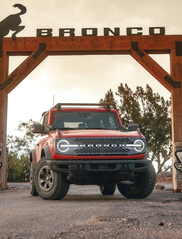 A red Bronco underneath a large wooden sign that reads Bronco.