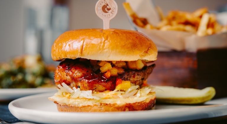 Delicious Hawaiian BBQ chicken sandwich with a side of crispy fries.