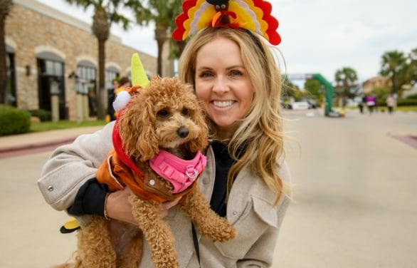 A close up of a woman holding her small dog