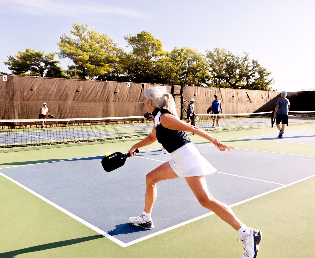 Woman hitting the pickleball to the other team