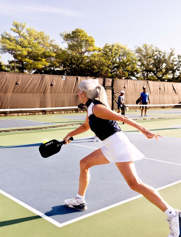 Woman hitting the pickleball to the other team