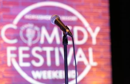 Mic in front of Comedy Festival Weekend logo at Horseshoe Bay Resort