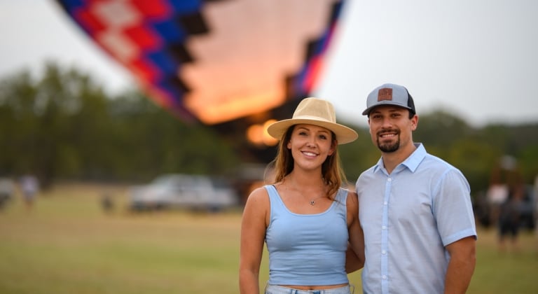 Couple in front of hot air balloons at Balloons over Horseshoe Bay Resort