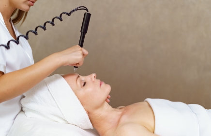 Woman getting a Hydrafacial with her hair in a towel.