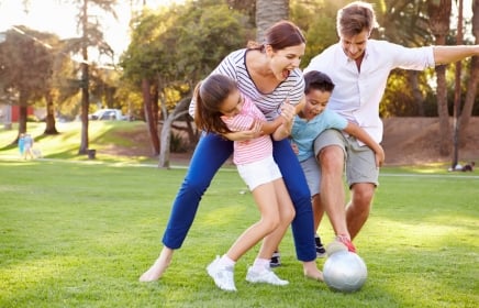 Family,Playing,Soccer,In,Park,Together