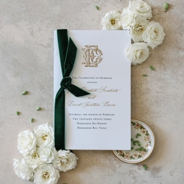 Wedding invitation with white flowers and envy green ribbon.