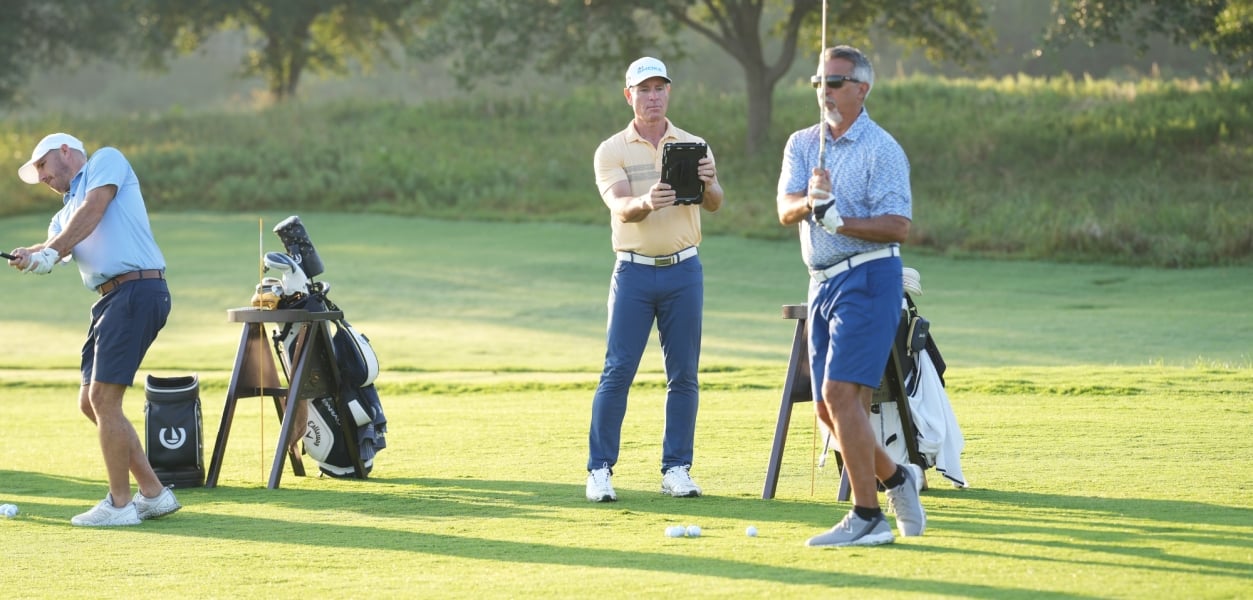 Golf coach watching a student tee off at the Golf Academy at Horseshoe Bay Resort