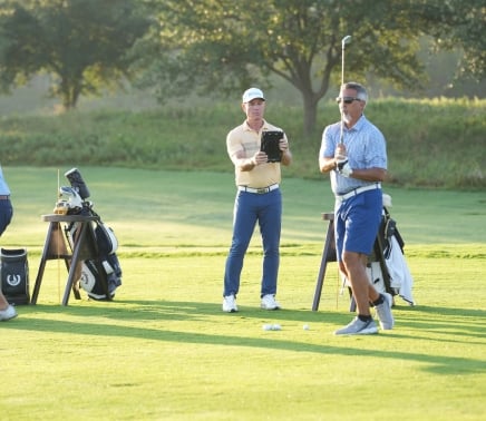 Golf coach watching a student tee off at the Golf Academy at Horseshoe Bay Resort