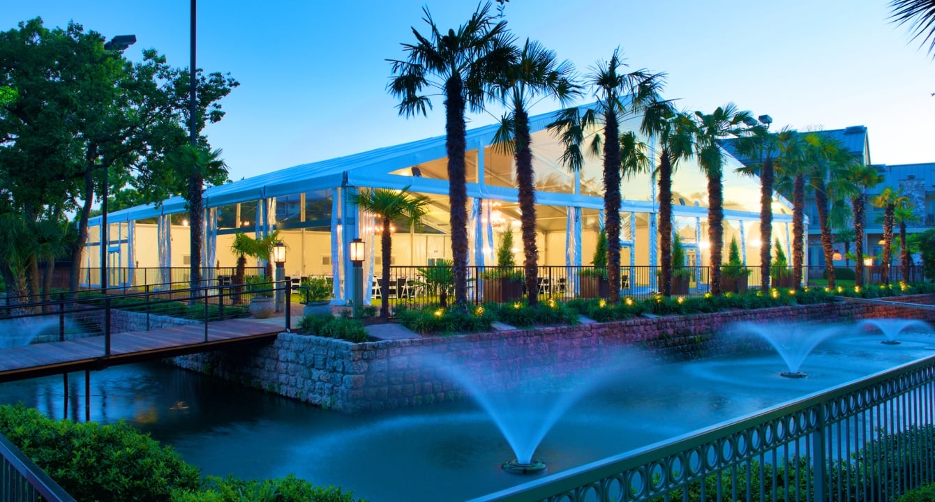 Large white tent for group events and parties overlooking a fountain.