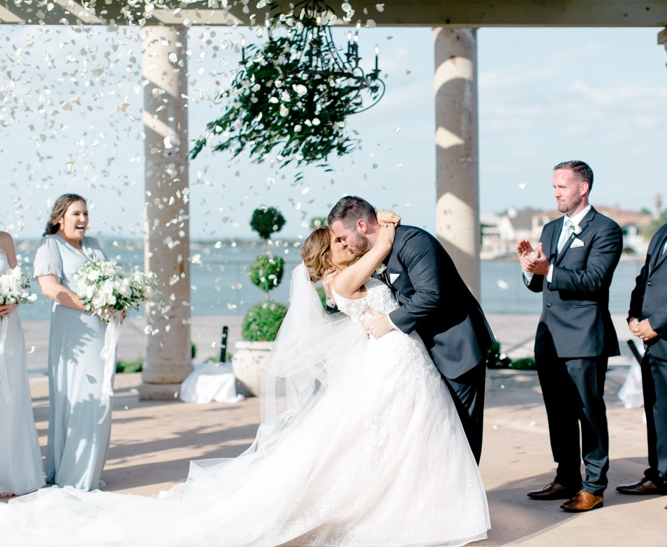 Bride and groom kissing as they confirm their love for one another at the alter.