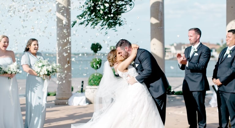 Bride and groom kissing as they confirm their love for one another at the alter.