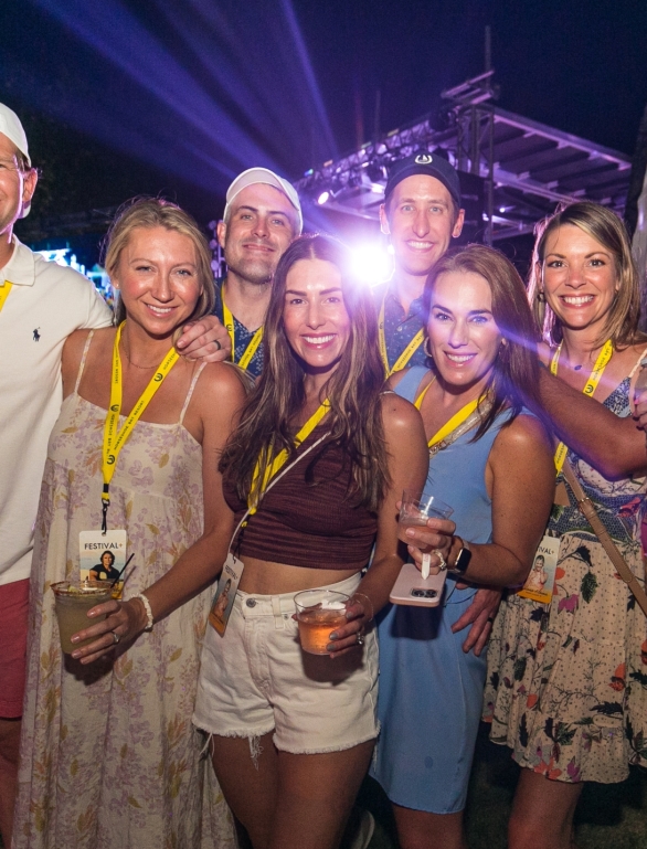 group of people posing for a photo at horseshoe bay resort with a stage in the background