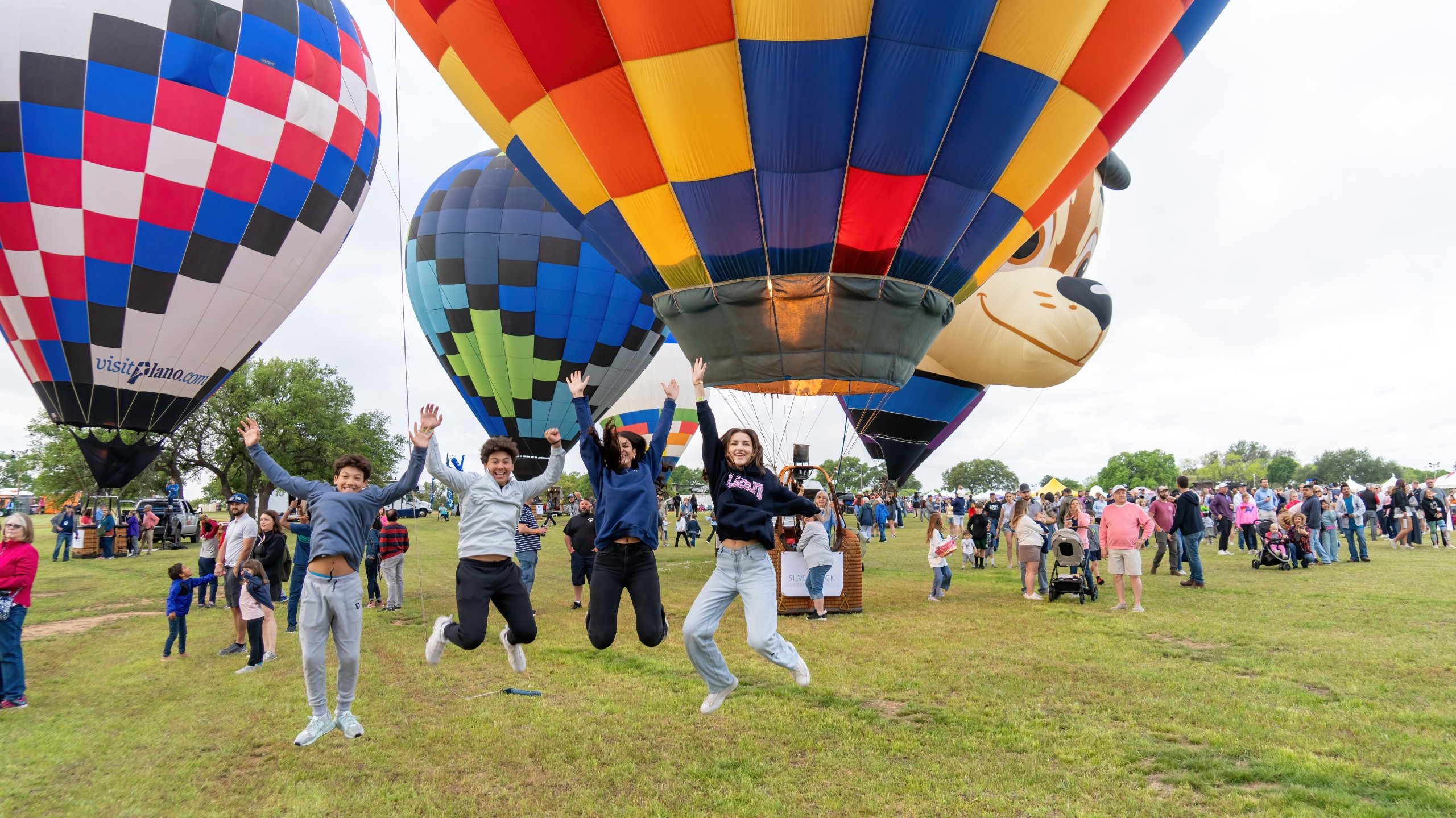 kids jumping in front of hot air balloons at balloons over horshoe bay texas