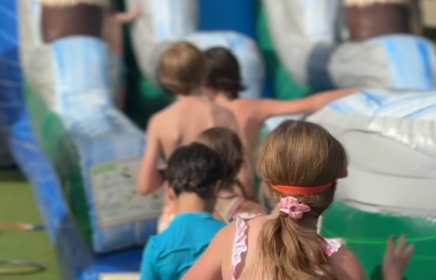 group of kids running to play on a inflatable water slide at horseshoe bay resort