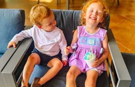 two kids sitting in a chair enjoying a cold treat at horseshoe bay resort