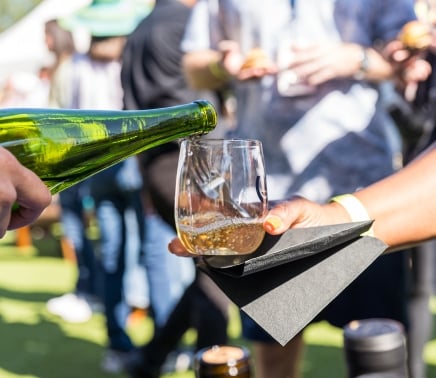 glass of wine being poured at the wine, dine, and jazz festival at horseshoe bay resort