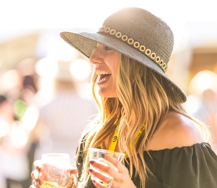 A woman laughing while enjoying some drinks at the Wine Dine & Jazz Festival at Horseshoe Bay Resort