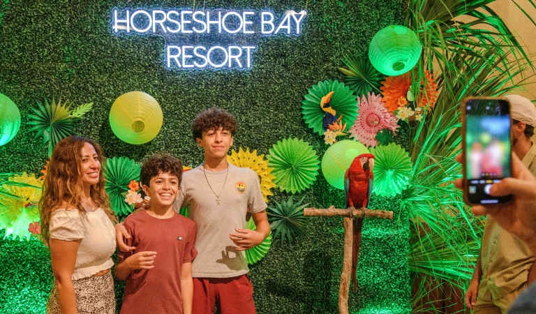 Guests at Horseshoe Bay Resort posing next to exotic birds